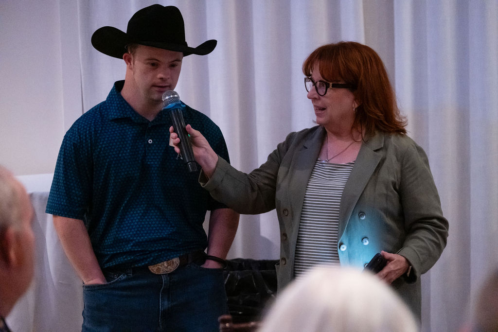 An auction winner being interviewed on the microphone