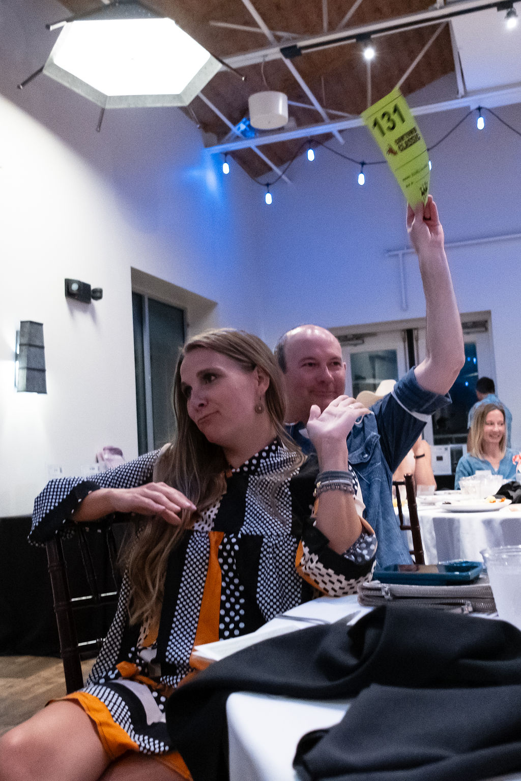 A bidder holds up her number