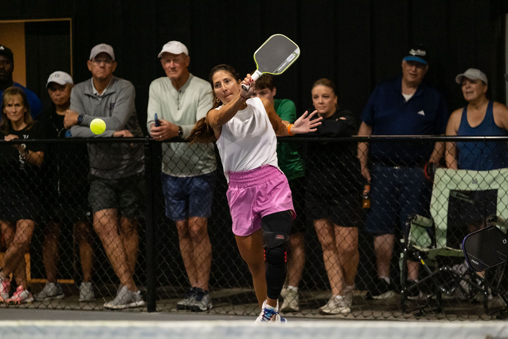 A backhand at the net with the crowd watching