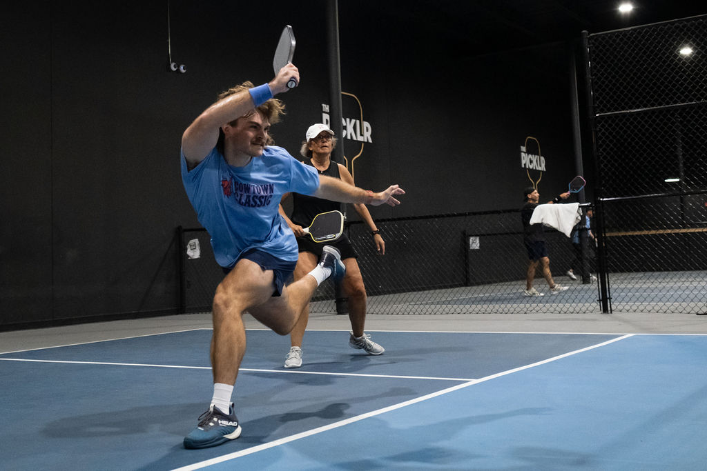 A player reaches for a wide ball