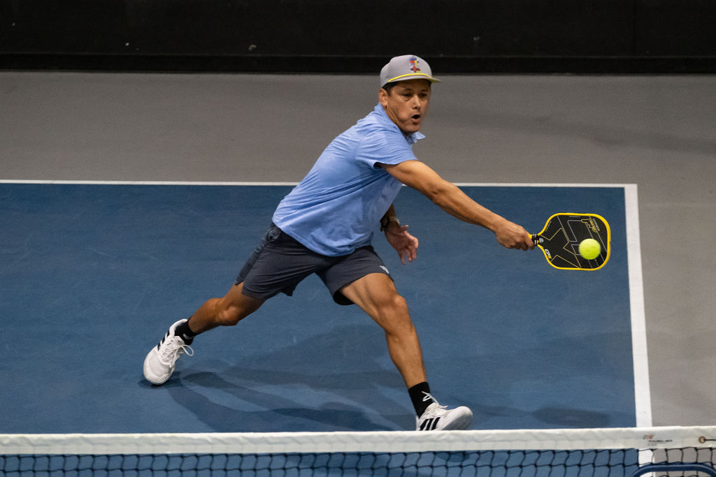 A player reaches for a low forehand